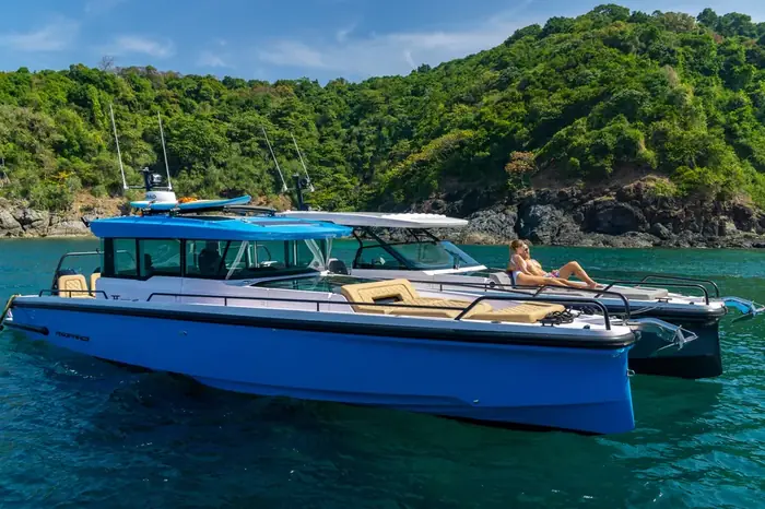 Embarcación fondeada en una caleta de aguas tranquilas rodeada de vegetación